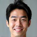 A smiling man in his 30s, Tanaka Kenta, looking confident.
